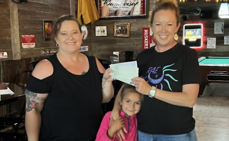 (Courtesy Photo) Smitty’s Place owner Misty Belsky (left) presents a check to Julie and Sloane Linders in benefit of the organization McKenna’s Rae of Hope.