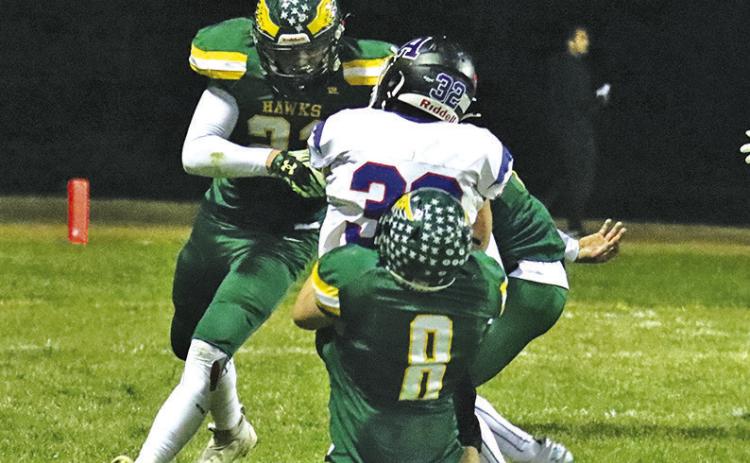 Photo by Scott Bidroski Hawk seniors Talan Smith (#21) and Hunter McDonald (#8) bring down an Arthur County ball carrier during the October 25 contest.