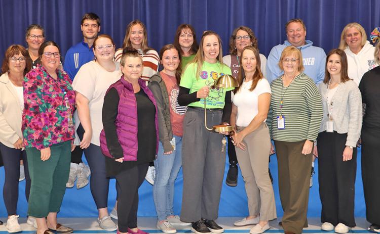 (Photo by Scott Bidroski) Gordon Elementary Principal Robin Johnson (center) takes a photo with her staff at Gordon Elementary on Monday, November 3. Johnson received the Lozier Foundation LIGHTS Outstanding Principal Award on Thursday, October 30 in Omaha. Johnson received $25,000 in monies to help improve GES along with a commemorative lamp, which is displayed above.
