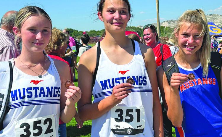 Photo by Amy Schmidt Some hardware came home on the Mustang bus following their races at Red Rocks Amphitheater in Gering, Neb. From left to right, Kynsleigh Krebs, Ashlyn Dehning, and Brittany Dehning all placed in the top ten during the days races.