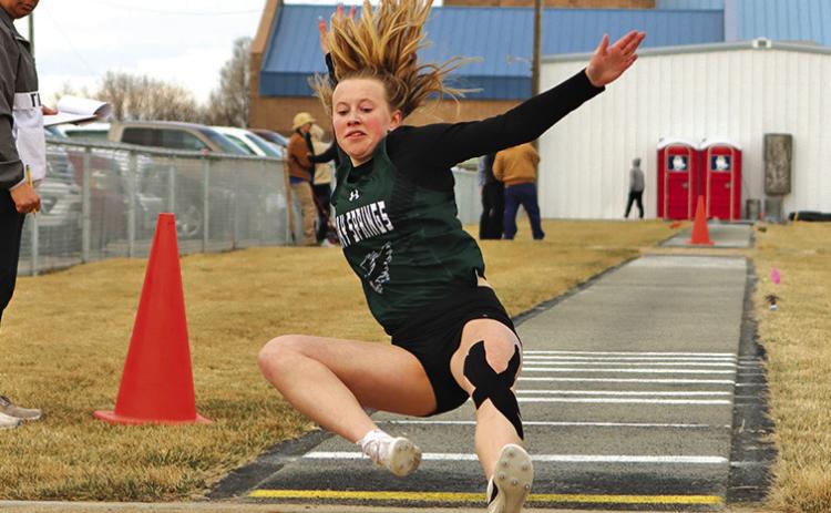 Photo by Scott Bidroski Freshman Reese Varvel slides into the landing pit during the Long Jump event in Bayard on March 28.