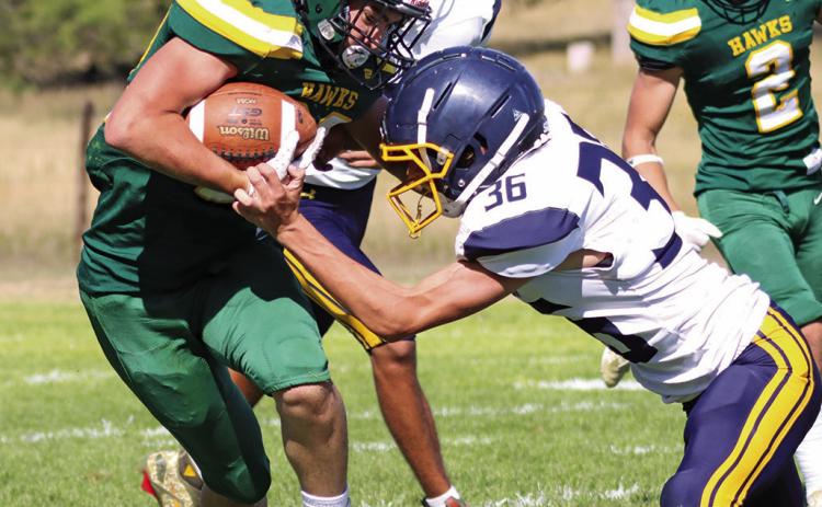 Photo by Scott Bidroski Senior Dylan Raymer absorbs the contact and sheds the Paxton defender. Raymer led the Hawks with 131 yards rushing and scored 2 touchdowns in the 28-14 Hawks win.