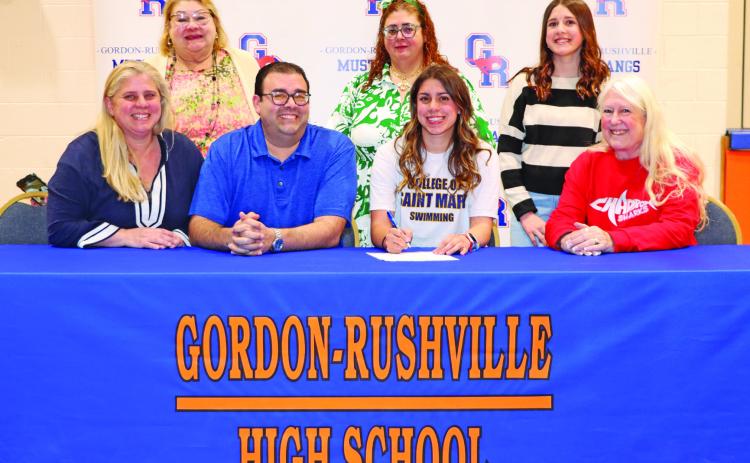 Photo by Scott Bidroski Gordon-Rushville High School senior Valeria Benitez-Socarres signed her Letter of Intent to swim collegiately at the College of Saint Mary’s on Monday, March 23. Benitez-Socarres was joined by her family and coach for the big event. Those pictured include: Sylmarie Socarres, Arelis Quintones, Jose Benitez, Arelis Benitez, Valeria Benitez-Socarres, Fabiola Benitez-Socarres, and Barb McCartney.