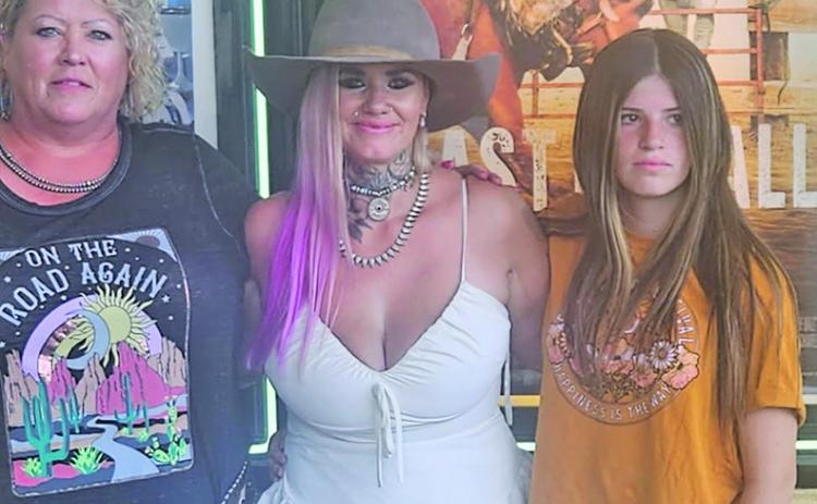 (Courtesy Photo) At the premiere event for East of Wall, Gordon Livestock owner Patsy Tines (left) takes a photo with the stars of the film, Tabatha Zimiga (center) and Porshia Zimiga (right).