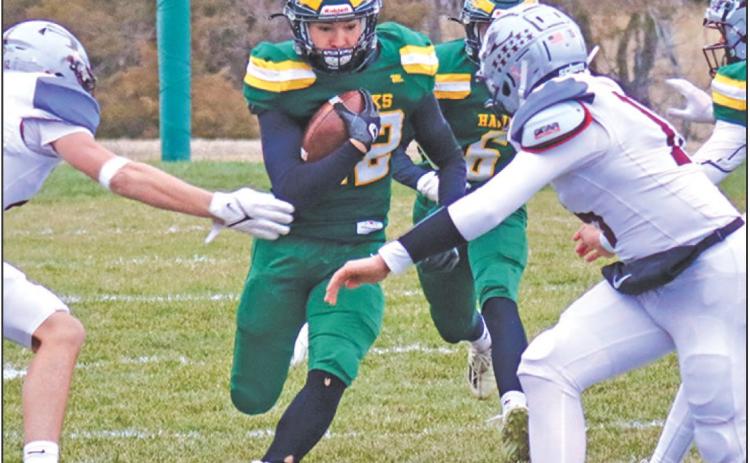 Photo by Scott Bidroski Senior Dylan Raymer pushes for a seam against the Silver Lake defense in the Hazvks 38-30 win over the Mustangs in the second round of the State 6-Man Playoffs on Friday, November 8, 2024.