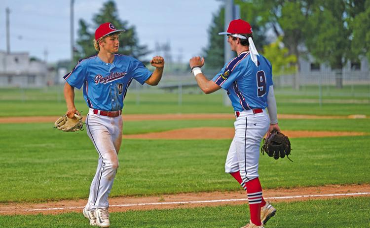 (Photo by Marlee Keracik) Tripp Buettner (#00) meets with teammate Bronson Freeseman (#9) following an inning during the Regulator Senior win, 15-6 on Sunday, June 15.